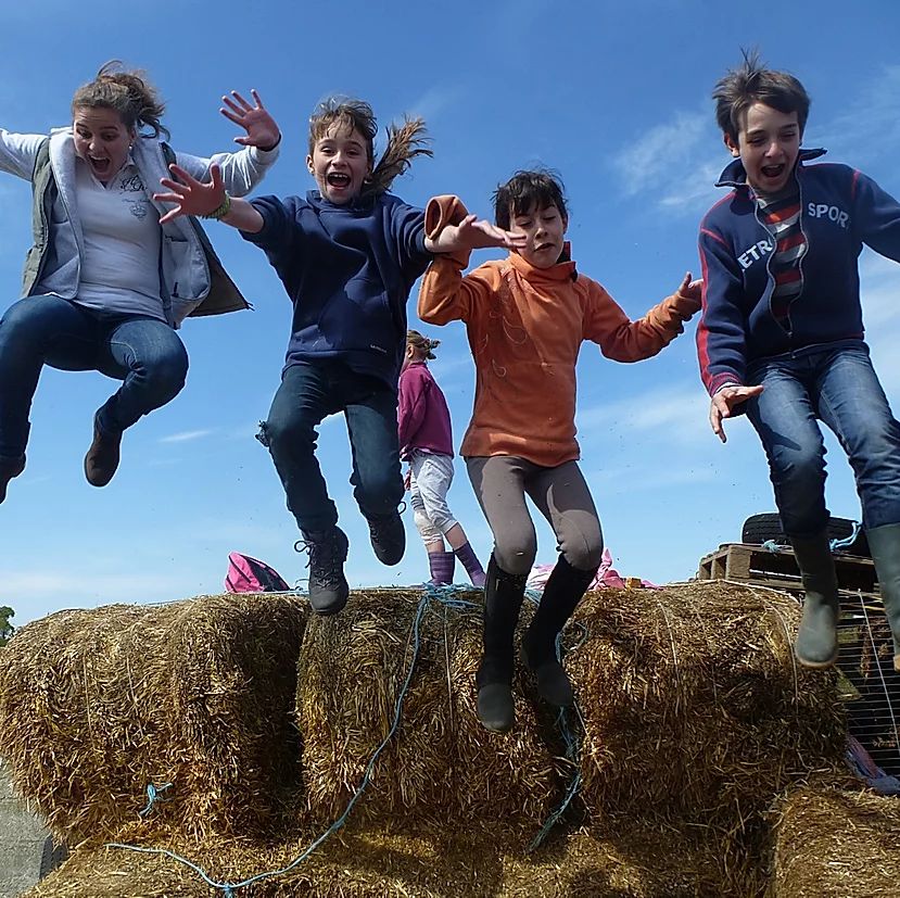 enfants qui sautent au dessus de balots de paille